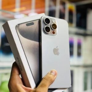 Close-up of a hand holding a silver iPhone with its box in a retail store.