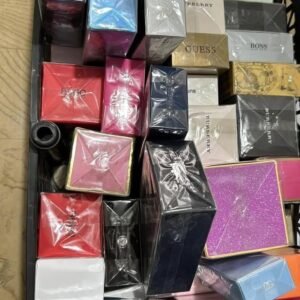Assorted perfume boxes in a crate, many wrapped in plastic with brands like Gucci, Boss, Burberry visible.